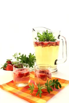 a glass of sweet woodruff punch with fresh strawberries