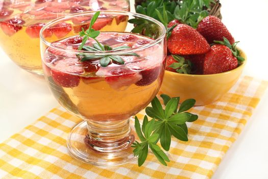 a glass of sweet woodruff punch with fresh strawberries
