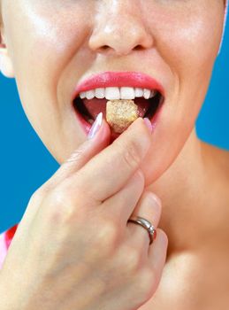 part of beautiful girl eats piece of sweets