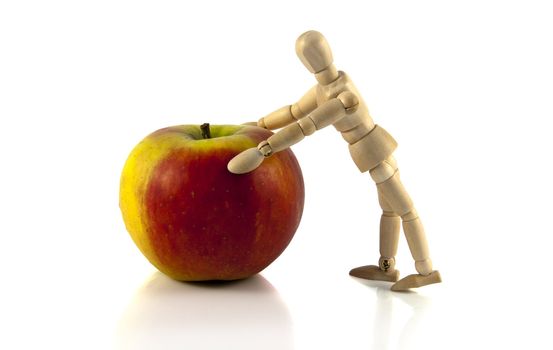 wooden male  puppet pushing the apple