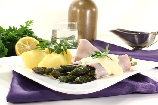 Asparagus with hollandaise sauce, potatoes and cooked ham