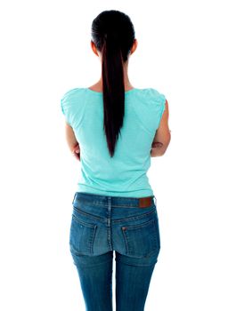 Beautiful young woman looking at wall. Rear view. Isolated over white.