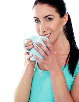 Smiling girl drinking coffee isolated over white