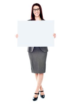 Portrait of a happy young woman holding a blank billboard over white background