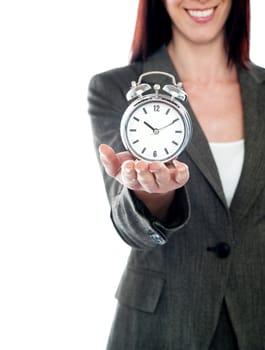 Cropped image of a woman holding alarm clock. Studio shot