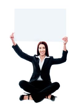 Corporate lady showing ad board over her head sitting on floor