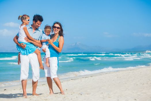 Family of four having fun on tropical beach