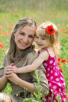 Happy mother and daughter in poppy field