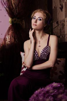 Retro-styled woman in violet dress sitting