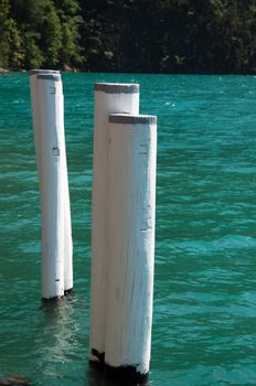 Old weathered bollard in great blue water at Lake Luzerne, Switzerland