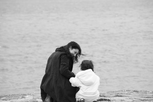 Back view of mother and daughter in beautiful spring sea