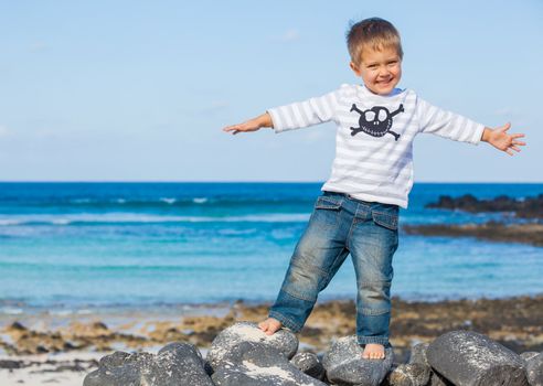 Cute boy dressed as pirate on tropical beach