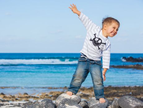 Cute boy dressed as pirate on tropical beach