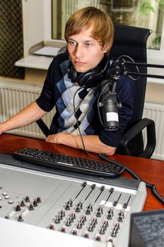 Anchorman sitting in front of a microphone on the radio