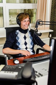 Anchorman sitting in front of a microphone on the radio