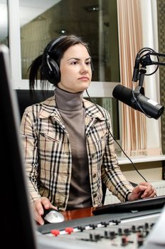 Anchorwoman sitting in front of a microphone on the radio