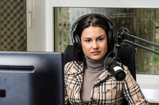 Anchorwoman in front of a microphone on the radio