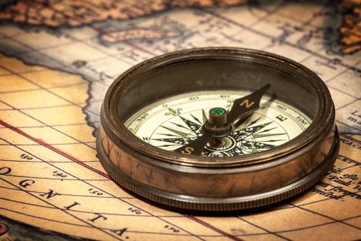 Old vintage retro compass on ancient map