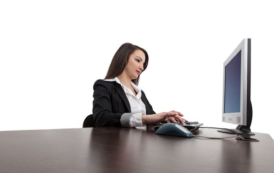 Image of a young brunette woman working on a computer at her desk, isolated against a white background.