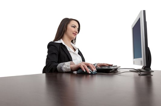 Image of a young brunette woman working on a computer at her desk, isolated against a white background.