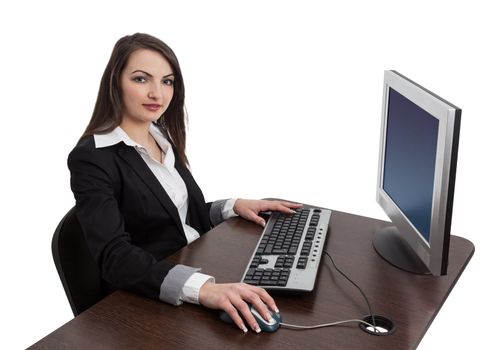 Image of a young brunette woman working on a computer while looking to the camera, isolated against a white background.