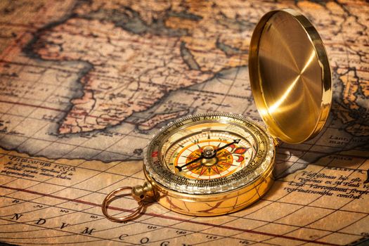 Old vintage retro golden compass on ancient map