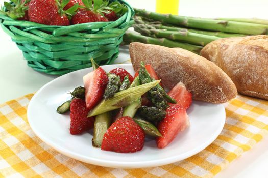 a plate of asparagus strawberry salad with roasted green asparagus