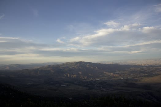 Clouds at dusk in the mountains. dark mountains and a bright blue sky.