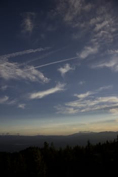 Clouds at dusk in the mountains. dark mountains and a bright blue sky.