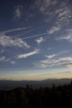 Clouds at dusk in the mountains. dark mountains and a bright blue sky.