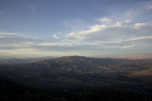 Clouds at dusk in the mountains. dark mountains and a bright blue sky.