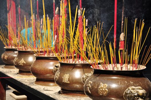 Incense or joss sticks burning in jars in a temple