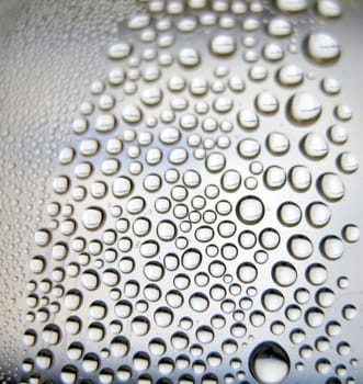 Water drops on the curve transparent surface. Shallow DOF.