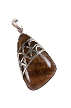 A Petriwood pendant made of silver used in alternative therapies like crystal healing and astrology, isolated on white studio background.