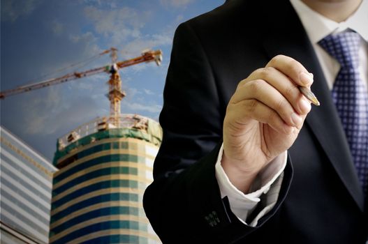 Businessman write with construction site background