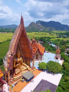 A view from the top of the pagoda, golden buddha statue with rice fields and mountain, Wat Tham Sua(Tiger Cave Temple), Tha Moung, Kanchanburi, Thailand