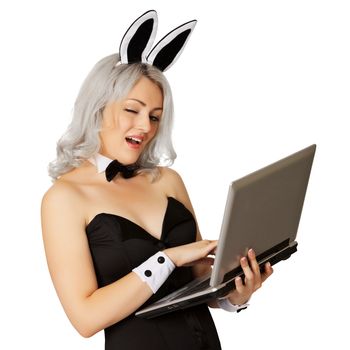 Playful girl - blonde dressed as a rabbit with a laptop