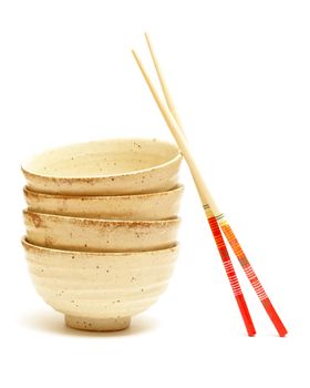 A stack of four rice bowls with chopsticks.