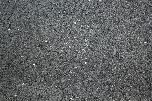 Asphalt texture with little pieces of glass looking as mirror in it