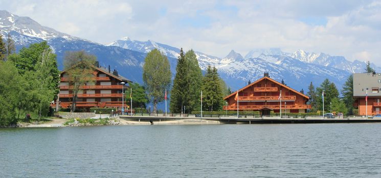 Swiss chalet, Long lake and Alps mountains in summer, Crans Montana, Switzerland