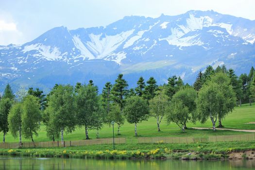 Long lake, trees at the golf place and mountain at Crans Montana, Switzerland