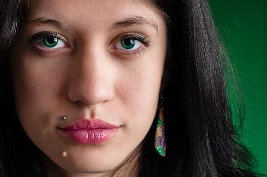 Female face highly detailed close up on green background