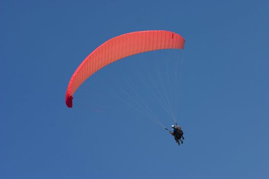 Parachute with soaring man on a background of the blue sky