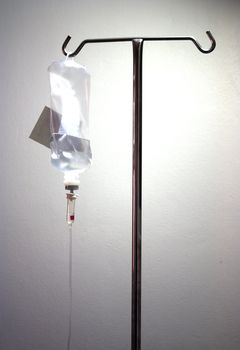 Infusion bottle with IV solution on white background 