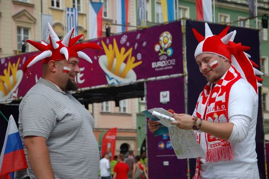 WROCLAW, POLAND - JUNE 8: UEFA Euro 2012, fanzone in Wroclaw. Two Polish fans talking and checking city map on June 8, 2012.