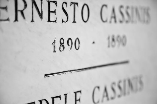 Old tombstone in Italian cemetery with birth and death dates