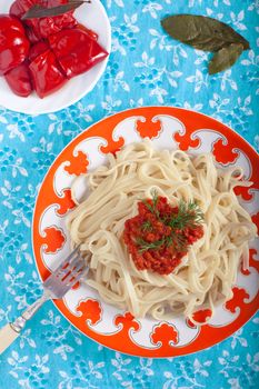 Pasta with tomato with pickled pepper on tablecloth 