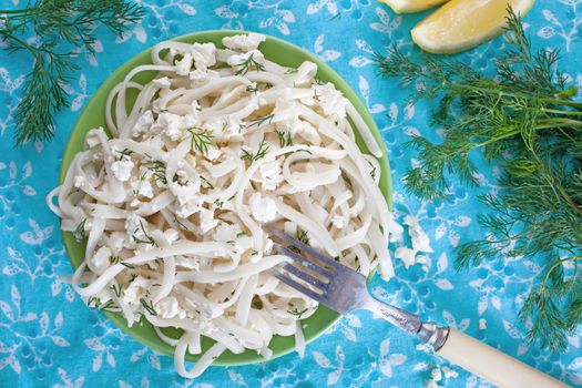 Pasta with cheese and greens on a floral tablecloth