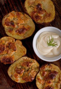 Baked potato with cheese, garlic and mushrooms on the wooden table