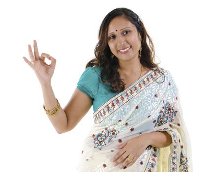 Beautiful Indian woman showing okay hand sign on white background